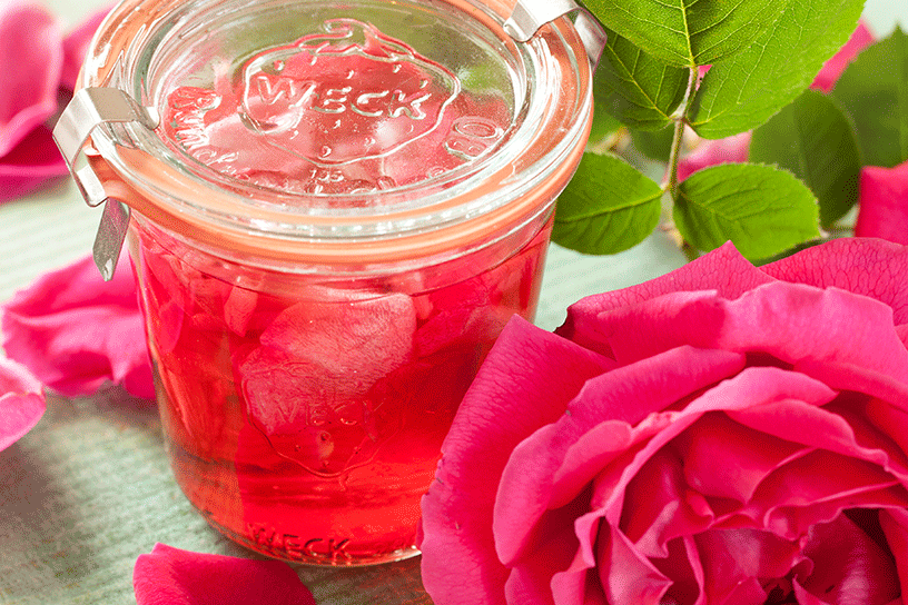 weckpot met azijn van rozenblaadjes en roos ernaast